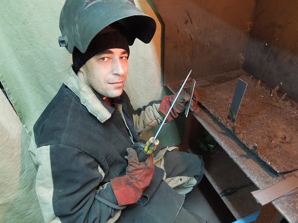 сварщик с электродом