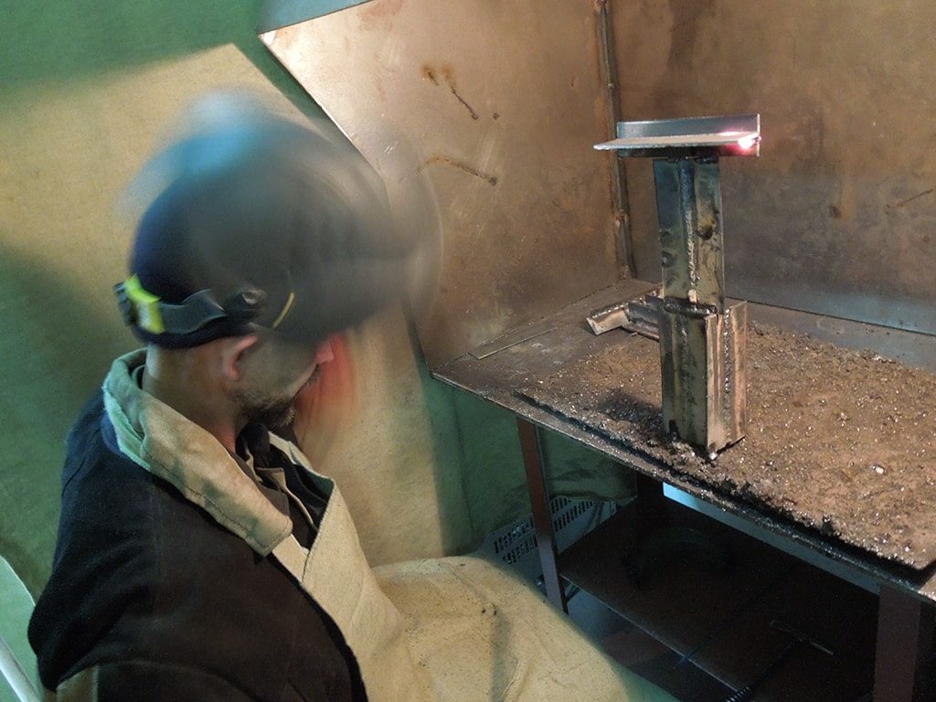 сварщик отбивает шлак